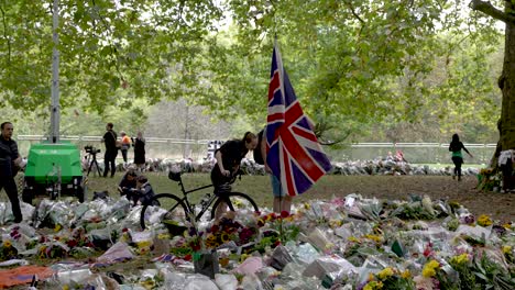 Large-Union-Jack-Flag-Fluttering-In-Wind-Surrounded-By-Floral-Tributes-For-Death-of-Queen-Elizabeth-II-In-Green-Park