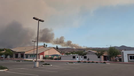 Planes-Extinguishing-Wildfire-in-Residential-Neighborhood-of-Hemet-California,-Black-Smoke-Rising-above-the-Sky,-City-in-the-USA,-View-from-the-Parking-Lot
