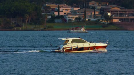 Tourism-season-in-Lago-Paranoa,-Brasilia,-Brazil,-two-boats-on-golden-hour-in-slow-motion