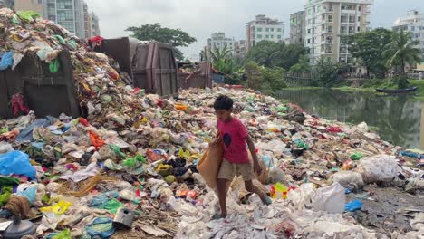 Street-child-walking-over-garbage-trash-in-a-landfill