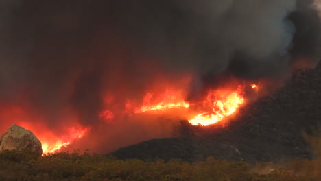 Raging-wildfire-spreading-along-mountainside-at-night,-Fairview-fire,-California