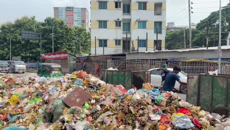 Workers-Seen-Clearing-Pile-Of-Street-Garbage-Beside-Road-In-Bangladesh-With-Traffic-Going-Past