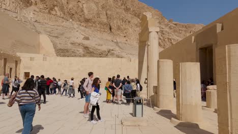Schwenk-über-Eine-Große-Anzahl-Von-Touristen,-Die-Die-Komplizierten-Details-Des-Totentempels-Der-Hatschepsut-In-Luxor,-Ägypten,-Bewundern
