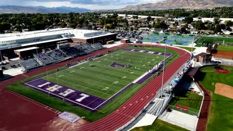 Football-game-at-Lehi-High-School-in-Utah---orbiting-aerial-view