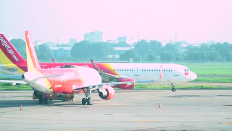 Colorful-passenger-airliner-taxiing-on-airport-asphalt,-follow-view