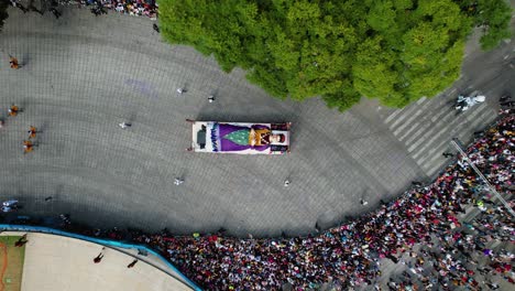 Aerial-view-above-a-truck-decorated-with-a-Dead-woman-lying-on-bed-at-the-Dia-de-Muertos-Parade,-in-Mexico-city---top-down,-drone-shot