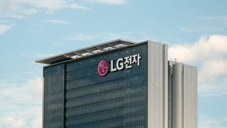Tilt-up-to-brand-logo-of-LG-Electronics-on-Seocho-Research-and-Development-Campus-building-against-blue-sky-with-clouds