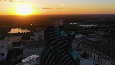 Aerial-view-overlooking-the-sunlit-Seminole-Hard-Rock-Hotel,-sundown-in-Hollywood,-Florida,-USA---reverse,-drone-shot