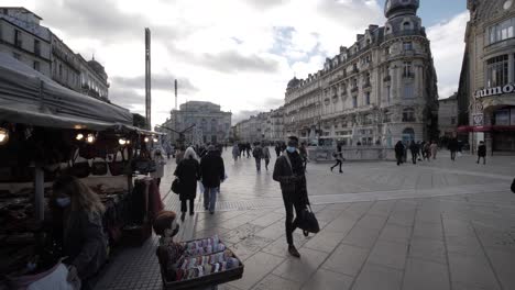 Slowmotion-Dolly-Shot-Revealing-A-Busy-Downtown-Montpellier-Square-From-Under-A-Street-Market