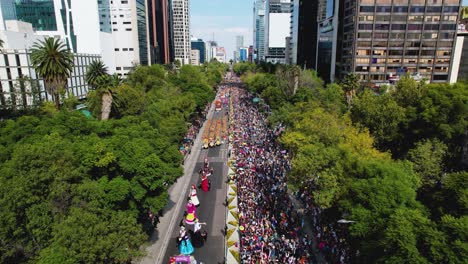 Aerial-view-overlooking-the-Dia-de-Muertos-Parade,-at-the-Reforma-avenue-in-sunny-Mexico-city