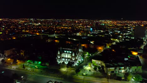Aerial-view-around-the-Quinta-Gameros-building-with-night-lights-in-Chihuahua-city,-Mexico---orbit,-drone-shot