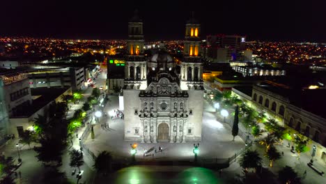 Illuminated-Metropolitan-Cathedral-of-Chihuahua,-during-nighttime---Aerial-view