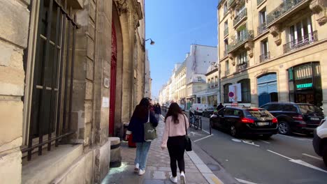 People-Walking-In-The-Sidewalk-With-Traffic-In-Rue-Vielle-du-Temple-In-3rd-Arrondissement-Of-Paris,-France