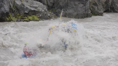 Group-of-two-rafts-paddling-down-extreme-powerful-mountain-river,-side-view