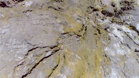 Volcanic-ground-surface-with-sulfur-and-geothermal-pools,-top-down
