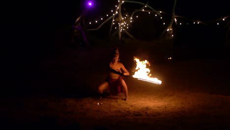 Asian-woman-in-tribal-attire-artistically-swinging-flame-sword-during-jungle-worship-ceremony