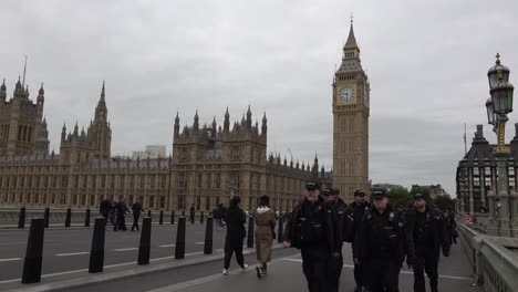 Police-walk-across-Westminster-Bridge-in-front-of-Big-Ben-and-the-Houses-of-Parliament-London,-UK