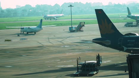 Busy-Vietnamese-airport-with-moving-vehicle-and-aircraft,-handheld-view
