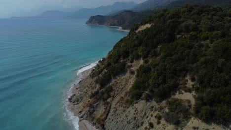 Drone-shot-of-the-Albanian-coast-in-the-Mediterranean-sea---drone-is-flying-over-a-beautiful-and-lonely-coastline