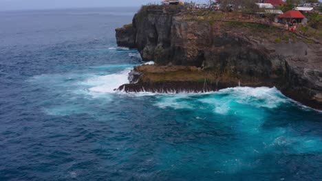 Stunning-aerial-shot-of-the-crashing-waves-and-many-shades-of-blue-water-at-the-cliff-of-Nusa-Penida-Angels-Billabong-in-Indonesia