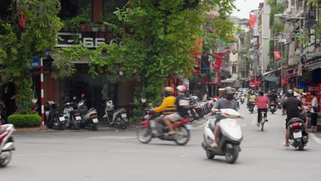 Typical-Vietnam-day-street-scene---motorcycle-traffic-at-intersection,-Hanoi
