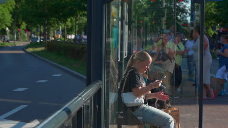 Das-Video-Zeigt-Ein-Junges-Mädchen,-Das-Ihr-Telefon-Benutzt,-Um-An-Einer-öffentlichen-Bushaltestelle-Eine-Sprachnachricht-Zu-Hinterlassen