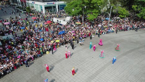Aerial-view-of-people-dancing-at-the-Dia-de-Muertos-Parade,-in-sunny-Mexico-city