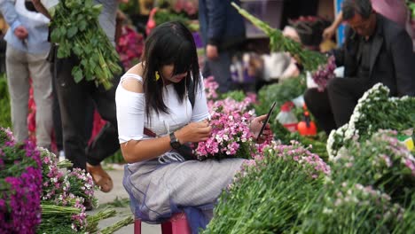 Kunming,-Yunnan,-China---September-1,-2022:-beautiful-seller-tidying-up-her-flowers-at-the-Kunming-Dounan-Flower-Market