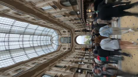 Vertical-shot-of-people-in-the-famous-Milan-shopping-mall-in-Italy