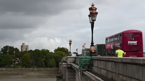 Walking-over-the-Putney-Bridge-towards-All-Saints-within-Fulham,-London,-United-Kingdom