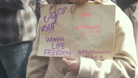 Woman-holding-sign-'Woman-Life-Freedom'-following-death-of-Mahsa-Amini