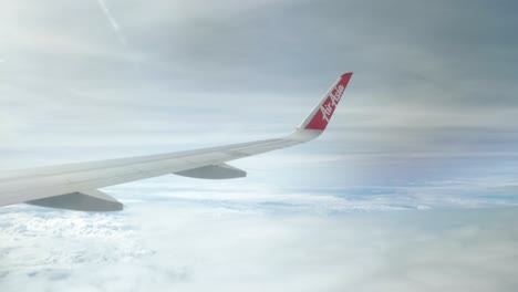 Blick-Auf-Den-Airaisa-Airbus-A320-Flugzeugflügel-Durch-Das-Flugzeugfenster,-Das-über-Die-Wolke-Fliegt