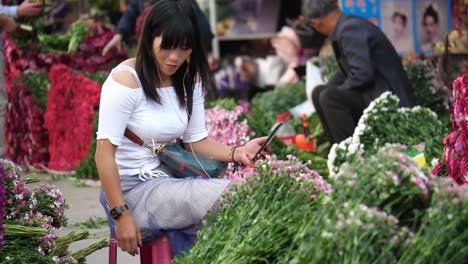 Kunming,-Yunnan,-China---September-1,-2022:-a-beautiful-seller-arranges-her-flowers-at-the-Kunming-Dounan-Flower-Market