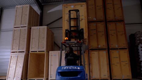 Forklift-putting-a-box-on-the-other-box-in-a-magazine