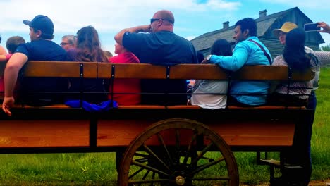 Early-1900s-horse-wagon-tour-with-modern-tourists-onboard-going-back-in-time-holding-up-phone-taking-pictures-videos-in-rural-farm-land-town-in-North-America-with-an-Edwardian-era-influence