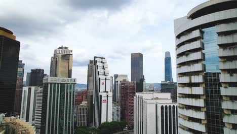 Kuala-Lumpur-skyline,-drone-ascending,-revealing-Menara-AIA-building