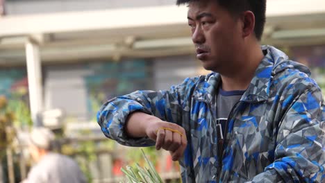 Kunming,-Yunnan,-China---1-De-Septiembre-De-2022:-Un-Hombre-Florista-Ocupado-Arreglando-Sus-Flores-En-El-Mercado-De-Flores-De-Kunming-Dounan