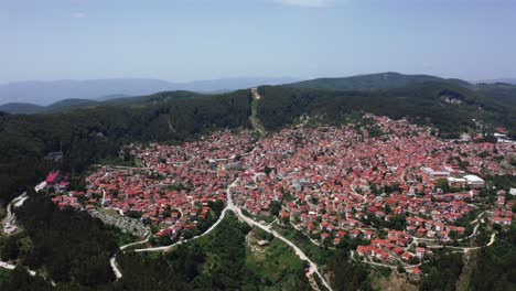Beautiful-aerial-wide-shot-of-the-Krushevo-City-in-Macedonia-which-is-in-a-valley-surrounded-by-forest-and-nature