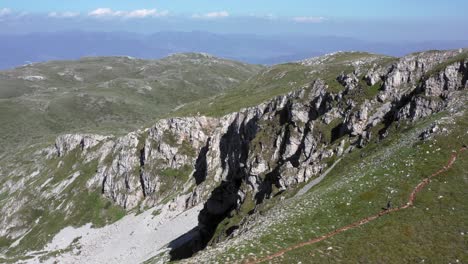 Atemberaubende-Filmische-Luftdrohnenaufnahme-Der-Felsigen-Berge-Des-Galičica-Nationalparks-Mit-Blauem-Himmel,-Flauschigen-Wolken-Und-Viel-Grün