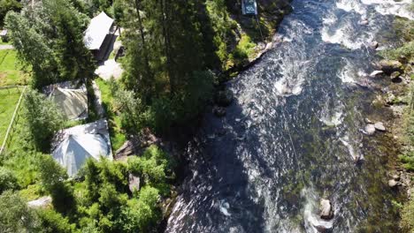 Zipline-crossing-above-river-stream-in-Voss-climbing-and-Zipline-park-owned-by-Voss-Active---Sunny-day-aerial-above-park-in-Voss-Norway