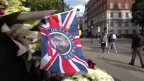 Union-jack-flag-with-the-Queen-on-is-left-at-memorial-in-central-London,-UK