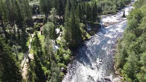 Person-riding-zipline-above-stranda-river-in-Voss-Norway---Voss-actice-zipline-and-climbing-park-aerial---Beautiful-surroundings-with-river-stream-and-forest-in-western-Norway