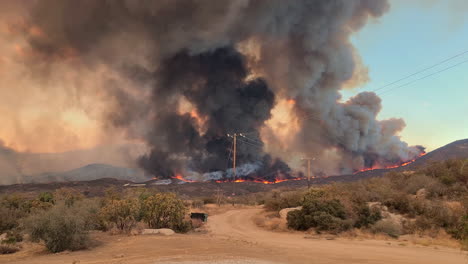 A-shot-tracking-a-fixed-wing-aircraft-swooping-down-dropping-water-onto-the-Fairview-Wildfire-in-an-attempt-to-extinguish-and-control-the-damage-being-caused-by-the-blaze,-Hamlet,-California