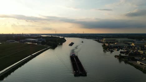 Aerial-Static-Shot-Over-Beneden-Merwede-During-Sunset-With-Silhouette-Of-Barge-Travelling-Along-Underneath
