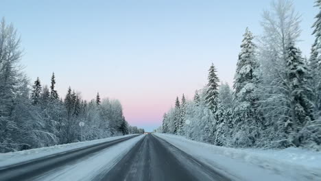 An-Einem-Klaren,-Kalten-Tag-Auf-Der-Winterstraße-Zwischen-Verschneiten-Wäldern-Fahren