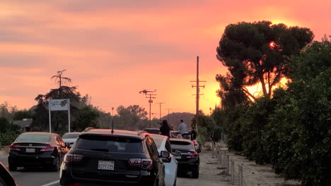 Bright-orange-and-red-sunset-in-California,-wild-fire-smoke,-people-watching