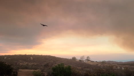 A-firefighter-aircraft-flies-over-an-area-of-burning-land-in-California,-USA