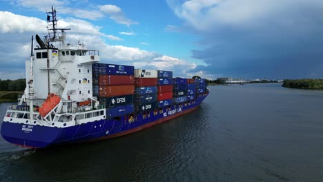 Aerial-Descending-Shot-Off-Stern-Starboard-Side-BG-Onyx-Cargo-Container-Ship-Sailing-Along-Oude-Maas-Through-Zwijndrecht