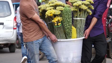 Kunming,-Yunnan,-China---September-1,-2022:-two-men-moving-flowers-at-the-Kunming-Dounan-Flower-Market