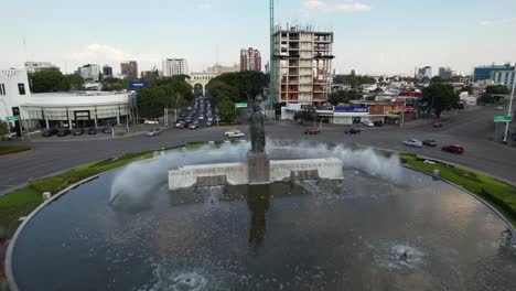 Aerial-view-over-statue-and-fountain-at-the-Minerva-Roundabout,-Guadalajara,-Mexico---rising,-drone-shot